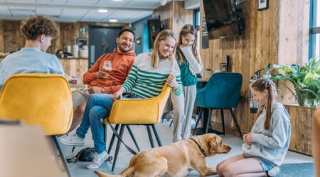 Family looking at a dog inside the eating area of The Hive Cafe at Devon Hills Holiday park
