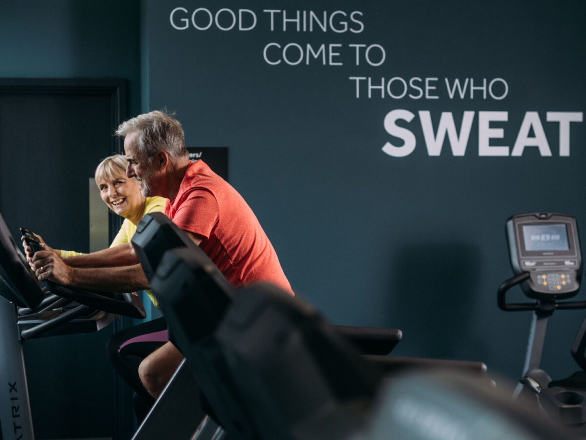 Older couple making the most of the gym area in a modern looking gym