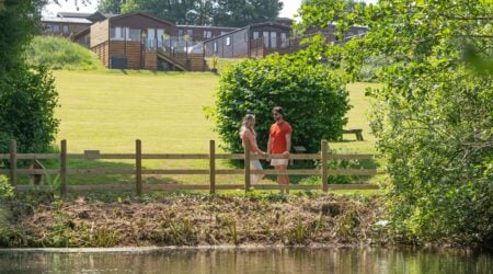 Family in front of Devon Hills holiday lodges