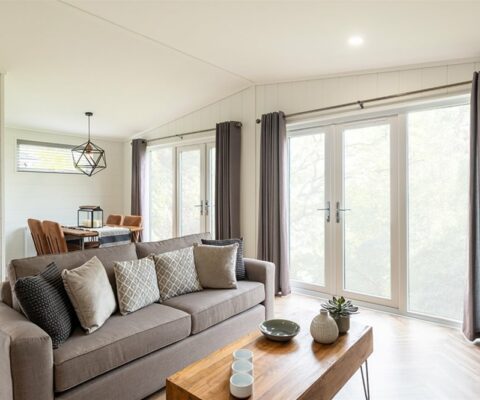 Open plan lounge with a grey sofa, parquet flooring in warm tones