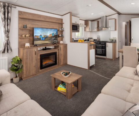 Open plan lounge and kitchen with tones of wood, cream and grey