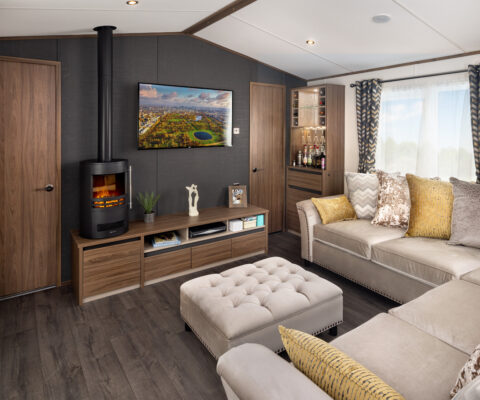 Carnaby Langham lounge area with five seater corner sofa fire place and TV mounted on the wall.