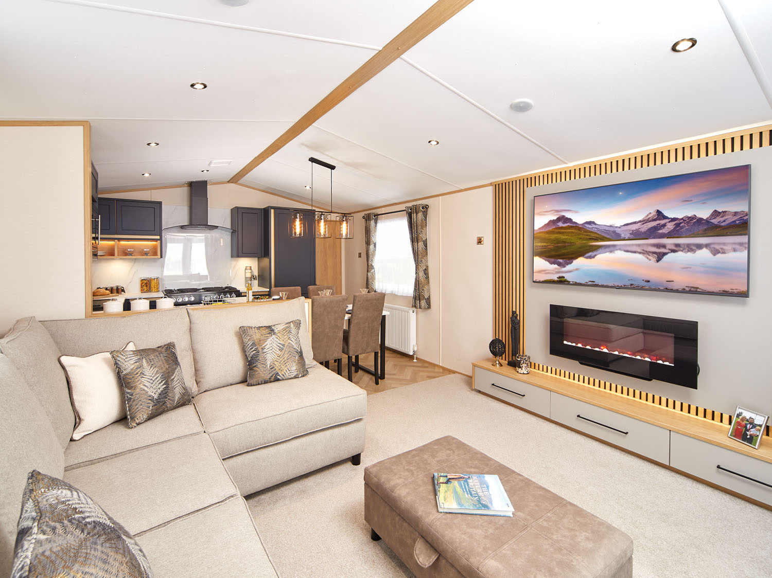 Carnaby Chantry lounge area with beige and cram color couch by the side of electric fire place and high res TV