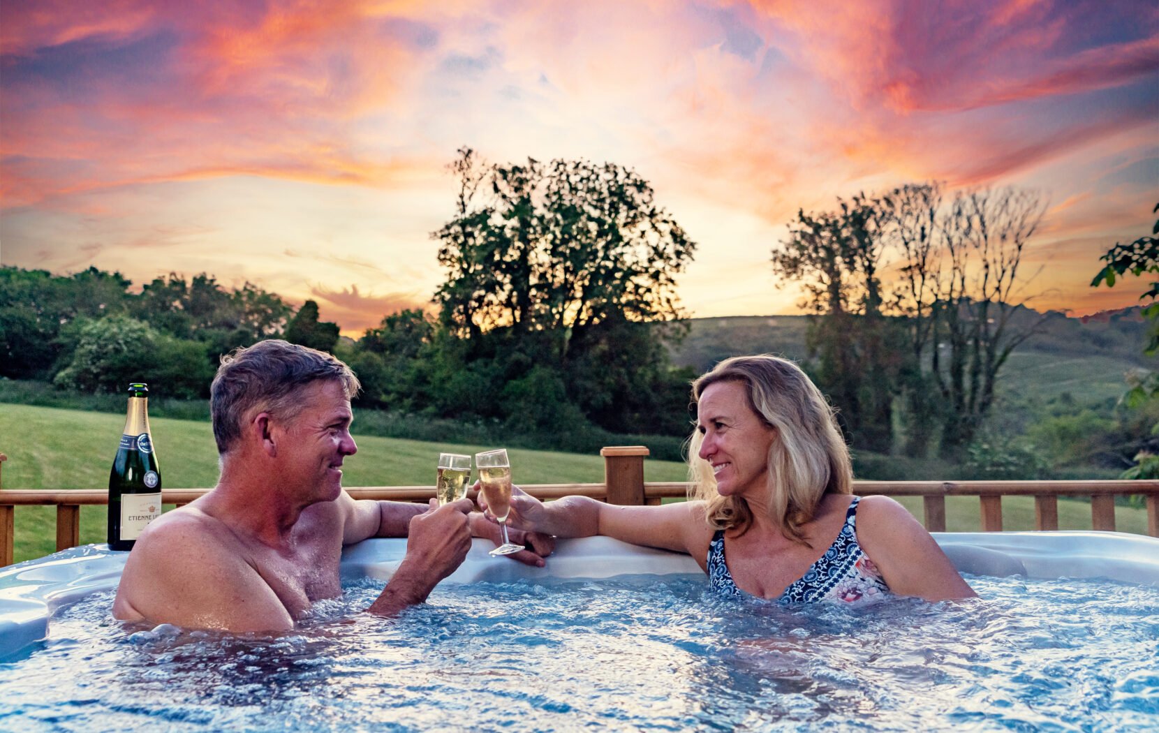 Couple in hot tub with stunning sunset