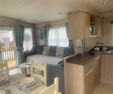 ABI Beachcomber open plan living area, grey couch and beige dinning table